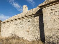 Chapelle Saint-Claude  La jontion entre le toit et les murs est faites de pierres taillées en demi-cercle sur lesquelles reposent de grosses pierres de taille plates