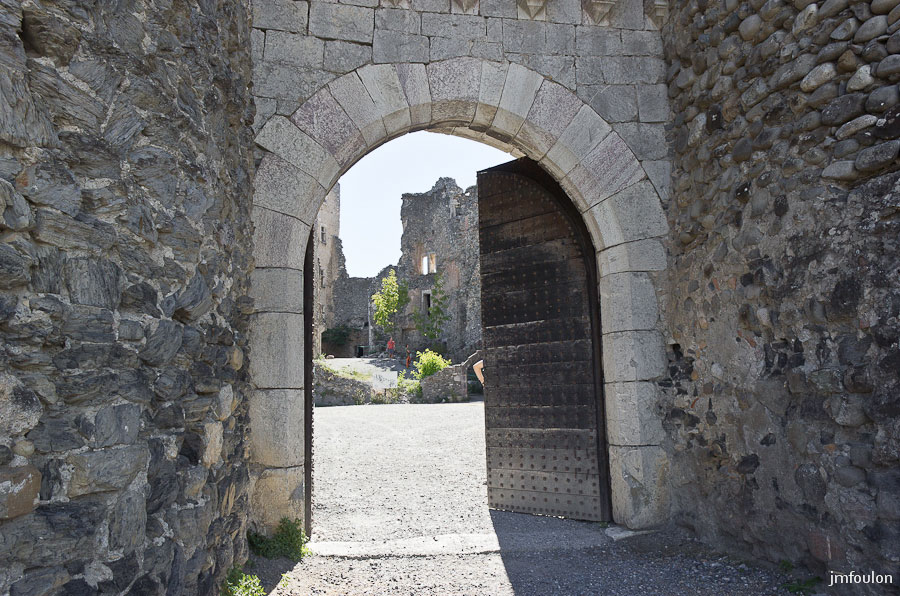 ch-tallard-inter-003.jpg - On pénètre dans le château par ce châtelet d'entrée surmonté d'un machicoulis et ceint de deux tours. La multitude de gros clous sur la porte servait à la faire résister au coups de bélier.