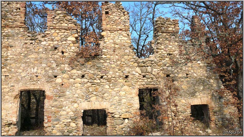 filature-11web.jpg - Cette façade est percée d'une multitude d'ouvertures. On voit les arcs de décharge en galets dans la maçonnerie, juste au dessus des linteaux de brique