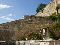 Grignan - Collégiale St Sauveur  Passage menant à un sentier qui longe le rempart jusqu'au Châtelet d'entrée du château.