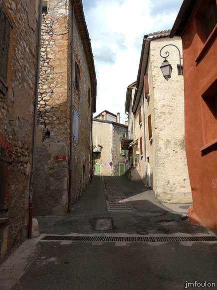 la-motte-11web.jpg - Au centre de la rue Casse Cul. A gauche et à droite la Traverse des Balcons. On remarque ici que la pierre qui protégeait le bas de  mur à l'angle de la maison à gauche des roues de charettes, est encore en place. En haut, l'ancien centre du village et la rue Sainte Catherine