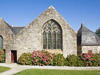 Sainte-Marie du Menez-Hom  La façade est de la chapelle donnant sur l'enclos illustre bien les étapes successives de sa construction : un granit de Logonna pour la partie sud, la plus proche du clocher, un granit plus sombre d'une autre provenance pour la partie médiane, un simple appareillage de grès armoricain avec du granit uniquement en entourage des portes et vitres pour la dernière extension construite entre 1570 et 1591 et dénommée « la chambre des moines »