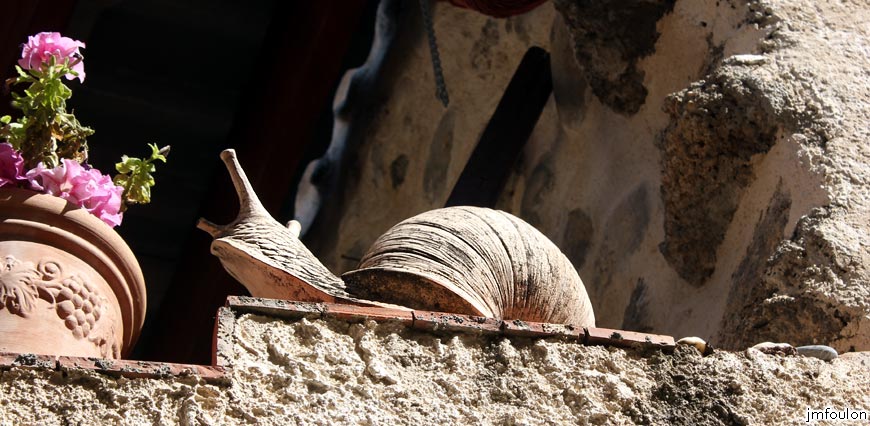 theze-21web.jpg - Théze - Escargot sur le muret Sud d'une terrasse. Ici, presque chaque maison possède une petite terrasse couverte