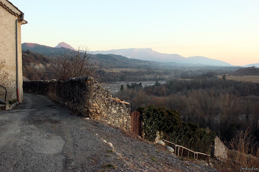 theze-33web.jpg - Théze - La rue la plus au Sud du village qui donne sur les jardins en restanques au pied de la Durance (voir la galerie dédiée). Au loin de gauche à droite: Hongrie (1189 m), Gache (1357 m), La Baume (1147 m) et le Molard (920 m) avec entre les deux: la Durance et Sisteron
