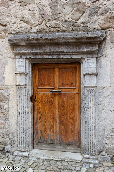 colmars-029.jpg - Colmars-les-Alpes - Place Saint Jean - Vieille porte sur le mur de l'église (entre le monument aux Morts et la chapelle Notre-Dame-des-Grâces).