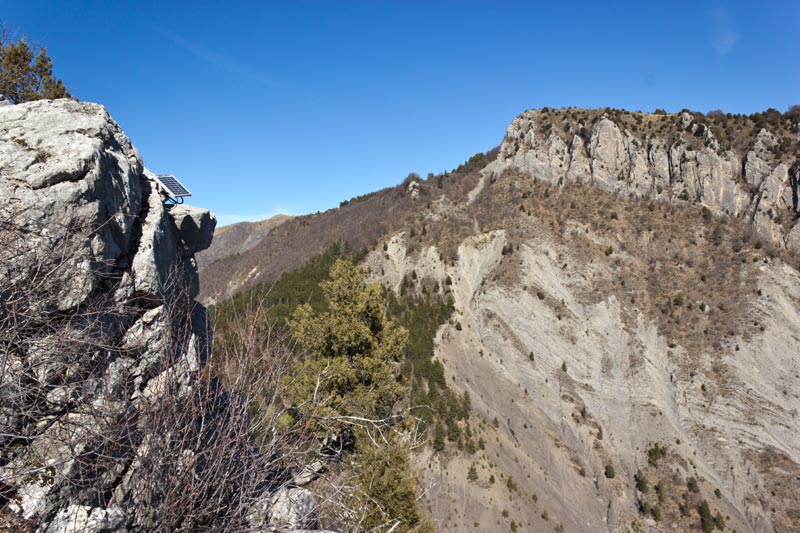 st-amand-29web.jpg - Ravin de la Combe et barre du Château. Nous arrivons à la chapelle St Amand. On voit d'ailleurs à gauche le panneau solaire qui alimente le rocher qui parle intallé ici par l'OT des Hautes terres de Provence