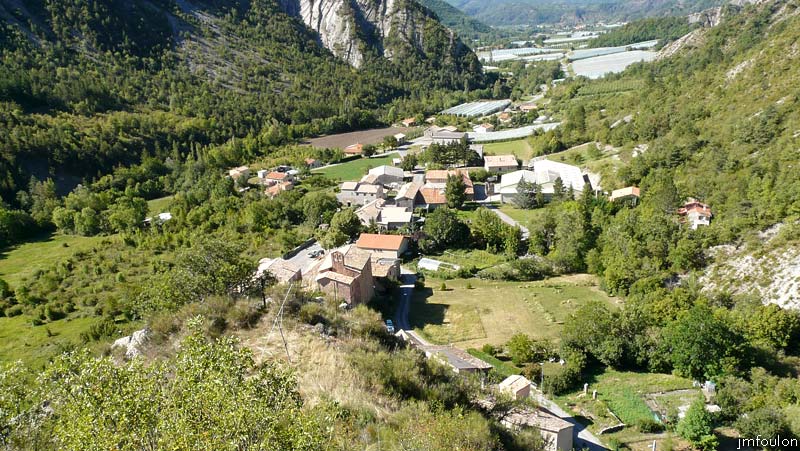 tour-le-caire-16web.jpg - Vue sur le village du Caire depuis la Tour. La plate-forme à gauche ou se trouve l'antenne de TV était sans doute aménagée. La partie la plus ancienne du village épouse le rocher en contrebas, formant un croissant. On retrouve ce type d'aménagement de façon presque systématique au Moyen-Âge dans la plupart des villages fortifiés de la région