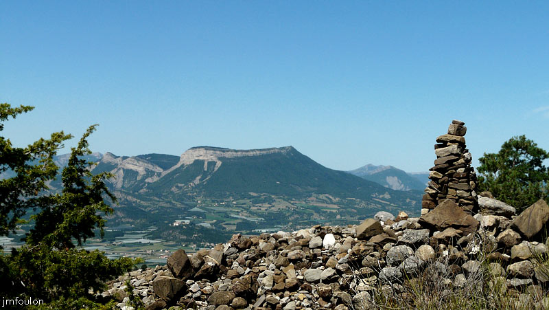 tour-melve-40web.jpg - Le chemin qui méne vers la Tour longe dans la montée un long pierrier qui s'étent du Sud vers le Nord. A la fin de celui-ci en arrivant sur le plateau ou est bâtie la Tour, se trouve se magnifique cairn. Vers l'Ouest, en arrière plan au centre, la Mtg de St Genis (1432 m au Roc de l'Esculier). Sous elle vers la gauche, on aperçois le village de Ventavon et son château sur une butte allongée