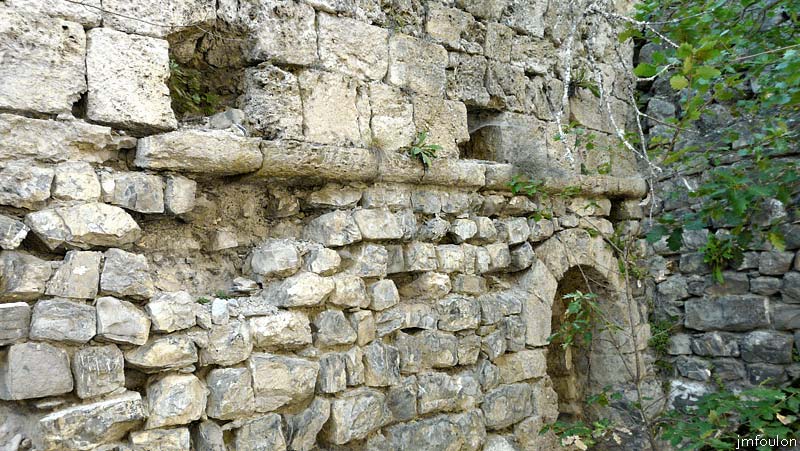 la-batie-34web.jpg - Vue sur la partie la plus au Nord du mur Ouest. On voit bien ici le cordon de pierre en quart de rond, les trous de poutres de l'étage vouté et l'arc intérieur de l'ouverture, en fait la seconde meurtrière par laquelle je suis entré